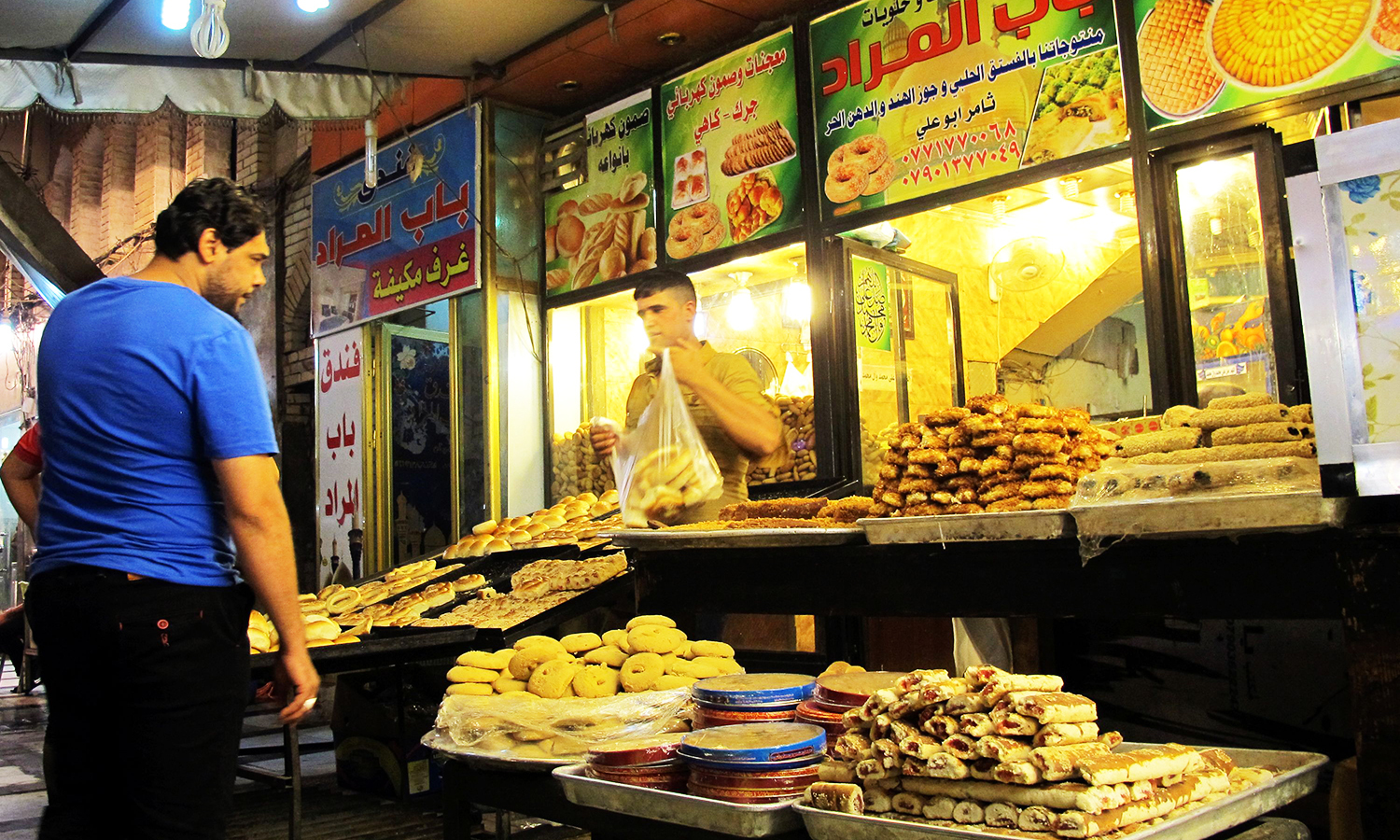 مرد عراقی برای خرید نان جلوی مغازه‌ای 
