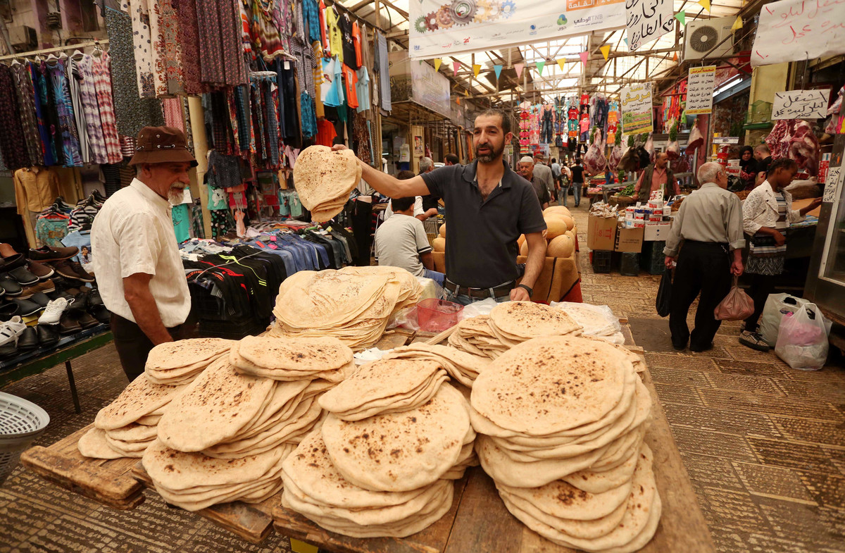 یک فروشنده فلسطینی در ماه مبارک رمضان در شهر نابلس نان می‌فروشد