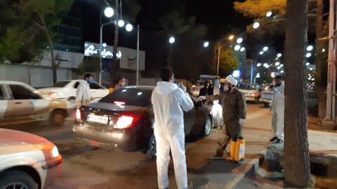 تعقيم السيارات على يد طلاب العلوم الدينية التعبويين في مدينة كرمان جنوبي إيران