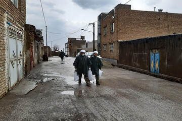 تصاویر/ توزیع مواد ضد عفونی توسط طلاب قرارگاه جهادی حوزه علمیه همدان در زیر بارش باران
