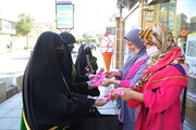 تصاویر/ اهدای شاخه گل توسط خادم‌یاران رضوی به بانوان قمی بمناسبت هفته عفاف و حجاب
