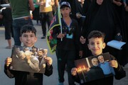 تصاویر شهدای مقاومت در دستان زائران اربعین