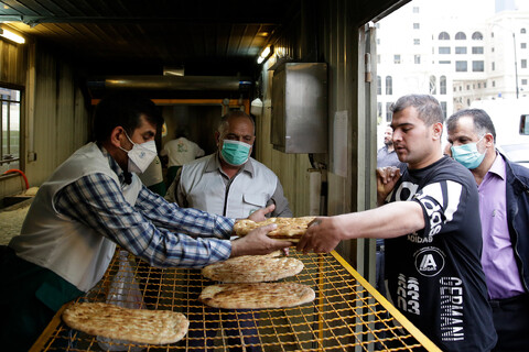 تصاویر/ پخت نان صلواتی در اطراف حرم مطهر رضوی