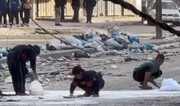 فیلم | کودکان غزه در حال جمع آوری آرد ریخته شده بر زمین