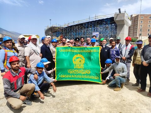 تصاویر حضور خادمان و پرچم متبرک حرم مطهر امام رضا(ع)در بین کارکنان طرح تقاطع غیر هم سطح امام رضا(ع)خرم آباد