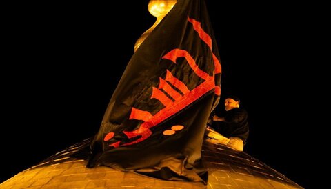العتبة الحسينية تستبدل الراية السوداء بالحمراء على قبة مرقد الإمام الحسين (ع)
