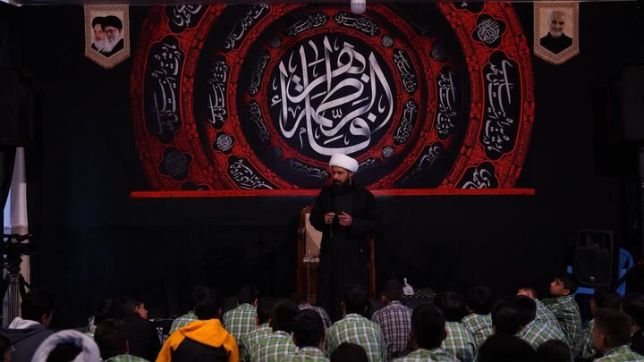 طلبه سخنران در حال تبیین بخش‌هایی از وقایع و معارف مرتبط با ایام فاطمیه در نمایشگاه کوچه‌های بنی‌هاشم.