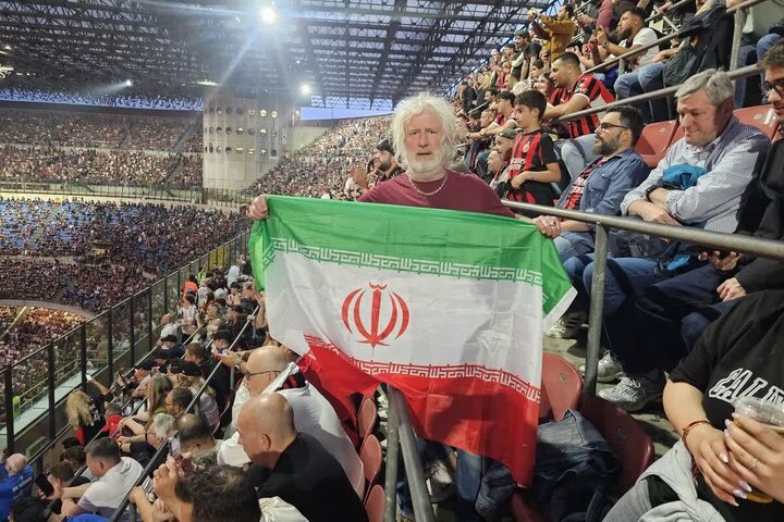 Mick Wallace ahudhuria San Siro akiwa na bendera ya Jamhuri ya Kiislamu ya Iran