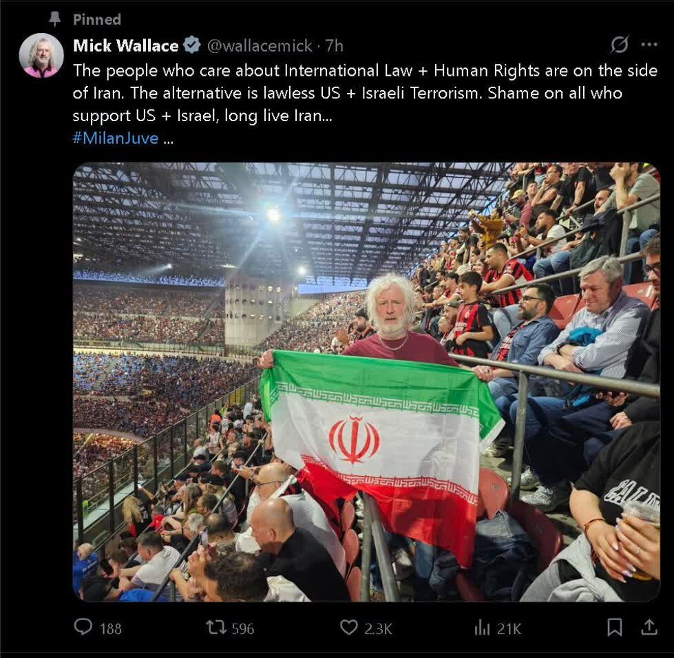 Mick Wallace ahudhuria San Siro akiwa na bendera ya Jamhuri ya Kiislamu ya Iran