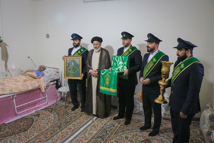 عیادت از جانباز قطع نخاعی جنگ رمضان به مناسبت روز ولادت حضرت رضا علیه السلام با حضور خادمان و پرچم متبرک حضرت معصومه سلام الله علیها