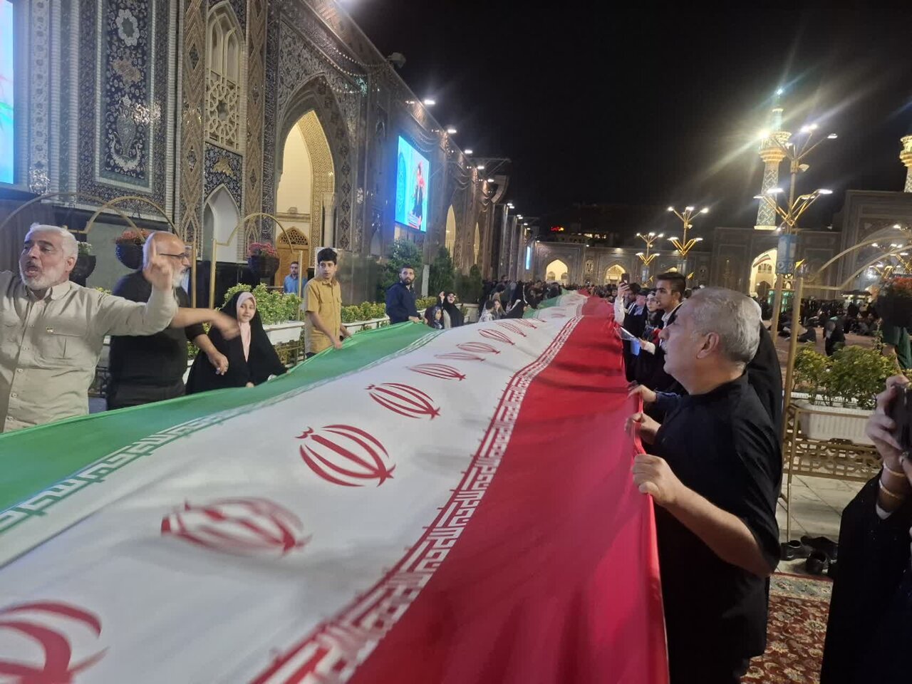 اهتزاز پرچم ۱۲۰متری کاشانی‌ها در حرم رضوی نمادی از مقاومت در برابر استکبار جهانی است