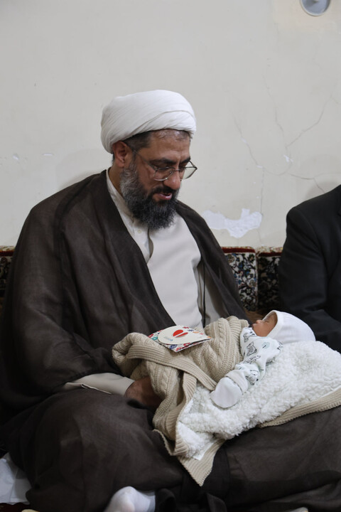 تصاویر / قرائت اذان و اقامه توسط امام جمعه همدان در گوش فرزند شهید ظفرمند
