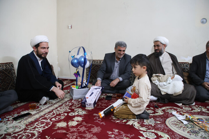 تصاویر / قرائت اذان و اقامه توسط امام جمعه همدان در گوش فرزند شهید ظفرمند