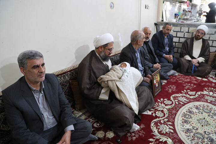 تصاویر / قرائت اذان و اقامه توسط امام جمعه همدان در گوش فرزند شهید ظفرمند