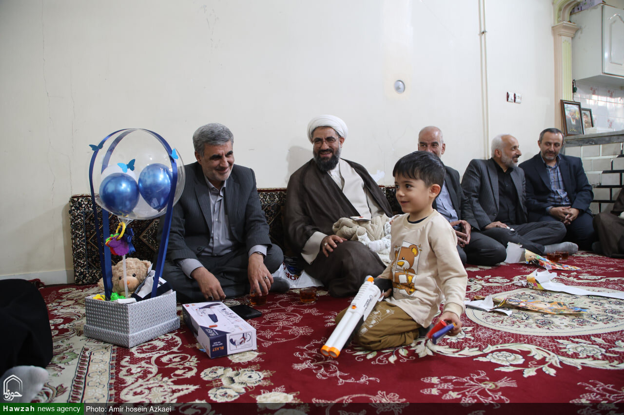 تصاویر / قرائت اذان و اقامه توسط امام جمعه همدان در گوش فرزند شهید ظفرمند