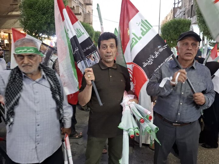 تصاویر/ کاشانی ها بیش از ۵۰۰ پرچم مشترک ایران و عراق را در کربلای معلا توزیع کردند