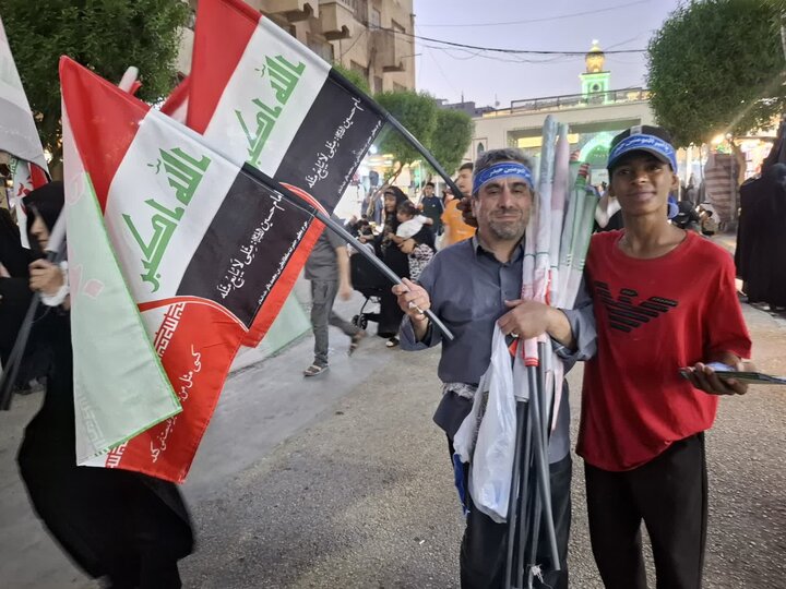 تصاویر/ کاشانی ها بیش از ۵۰۰ پرچم مشترک ایران و عراق را در کربلای معلا توزیع کردند