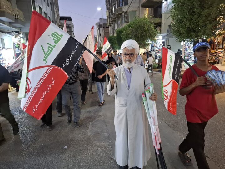تصاویر/ کاشانی ها بیش از ۵۰۰ پرچم مشترک ایران و عراق را در کربلای معلا توزیع کردند