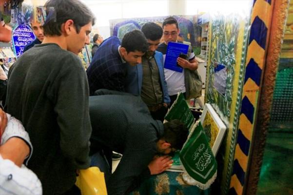 توافد رواد معرض طهران الدولي للكتاب للتبرك براية أمير المؤمنين (ع) في جناح العتبة العلوية